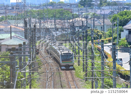 高台のフェンス越しに見るJR宇都宮線の通勤電車、E233系：埼玉県蓮田市 115258064