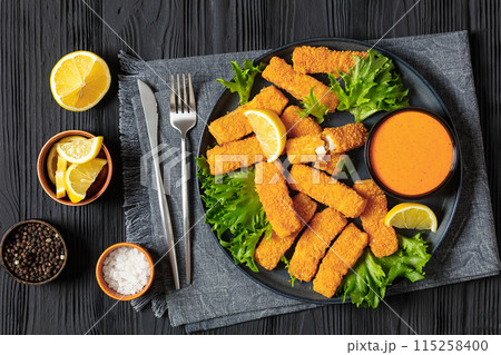 crispy fried breaded fish sticks on a plate 115258400