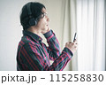 スマホで音楽を聴く若い男性 115258830