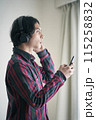 スマホで音楽を聴く若い男性 115258832