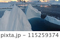 Huge towering icebergs melt in blue ocean bay. Arctic landscape. Ice glacier polar nature environment. Arctic winter landscape, global warming. Climate change in sunset landscape. Close up aerial shot 115259374