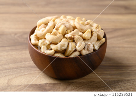 Raw cashew nuts in bowl on wooden background, Food ingredient 115259521