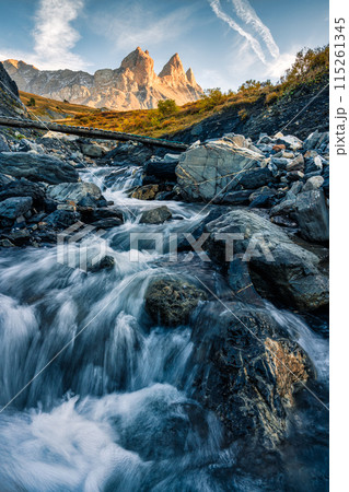 French alps landscape of iconic mountain Aiguilles d Arves and waterfall flowing in the valley on autumn at France French alps landscape of iconic mountain Aiguilles d Arves and waterfall flowing in the valley on autumn at France 115261345