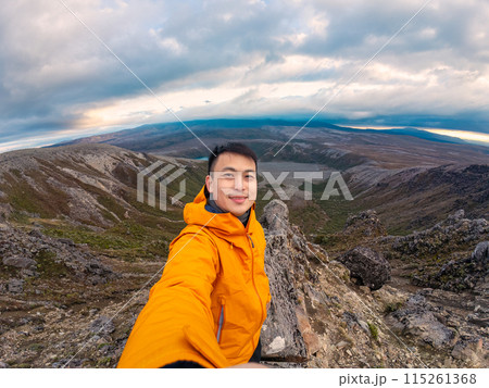 Traveler man enjoying success on top of mountain and Tama Lake view in Tongariro national park at New Zealand 115261368