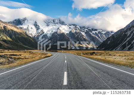 Road trip with asphalt road leading to Mt Cook with snow capped among grassland in national park at New Zealand 115263738