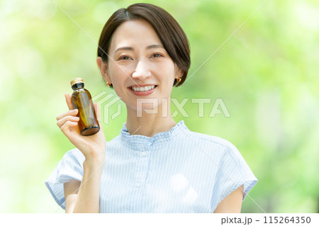 栄養ドリンクを飲む女性　新緑 115264350