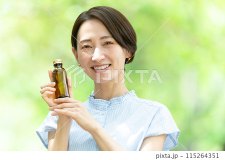 栄養ドリンクを飲む女性　新緑 115264351