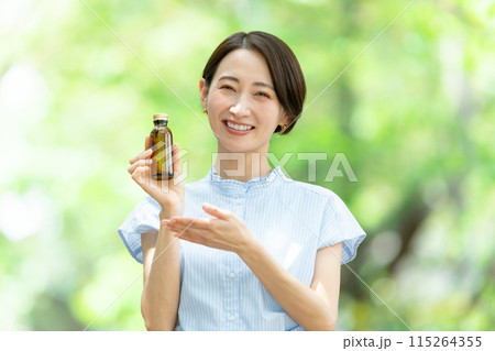 栄養ドリンクを飲む女性　新緑 115264355