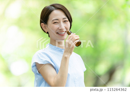 栄養ドリンクを飲む女性　新緑 115264362