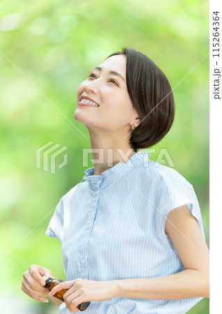 栄養ドリンクを飲む女性　新緑 115264364