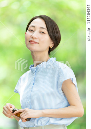栄養ドリンクを飲む女性　新緑 115264365
