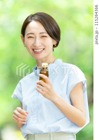 栄養ドリンクを飲む女性　新緑 115264366