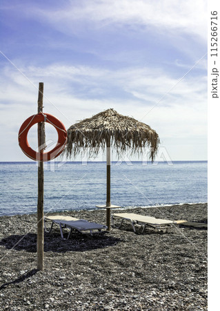 Beach umbrella, deck chairs and a lifeline Beach umbrella, deck chairs and a lifeline 115266716