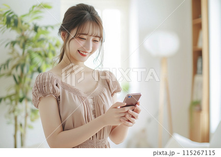 リビングでスマートフォンを使う若い女性 115267115