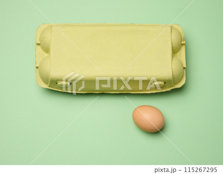 Chicken egg and paper storage box on green background, top view 115267295
