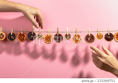 Orange, lemon and lime slices are dried on a line. 115269751