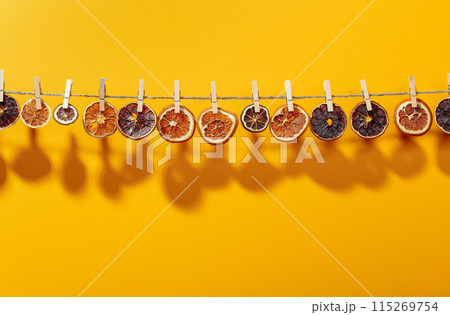Orange, lemon and lime slices are dried on a line. 115269754