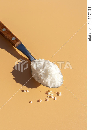 Top View Mockup Kosher Mineral Unrefined Sea Salt in Table Spoon, Natural Grain Crystals, Copy Space for Text. Beach Yellow Background. Baja Salt. Vertical Plane, Template 115271554