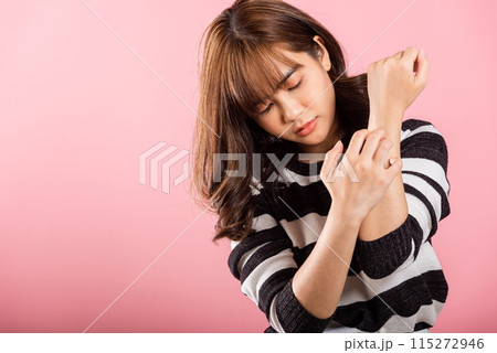 Asian beautiful woman itching her scratching her itchy arm on pink background with copy space, Medical and Healthcare concept, female skin problems scratch the itch with her arm 115272946