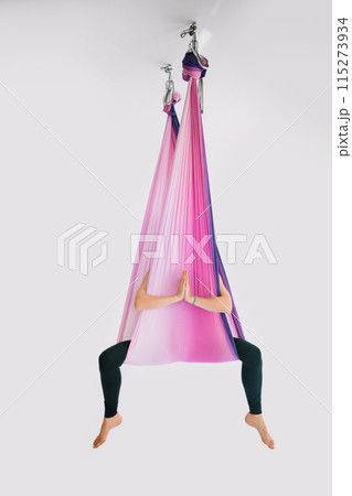Fly yoga woman meditating in hammock indoors. Fly yoga woman meditating in hammock indoors. 115273934