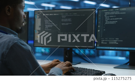 Technician doing system analysis, typing data on PC, doing needed adjustments in supercomputers server farm housing advanced data storage infrastructure supporting critical IT workloads, close up 115275275