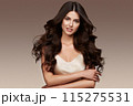 Beautiful brown-haired girl with a perfectly curls hair, and classic make-up. Beauty face and hair. 115275531
