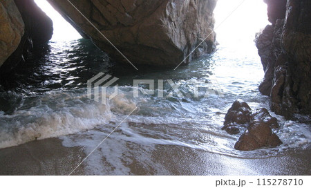 海岸の奇岩の洞穴に打ち寄せる白波 115278710