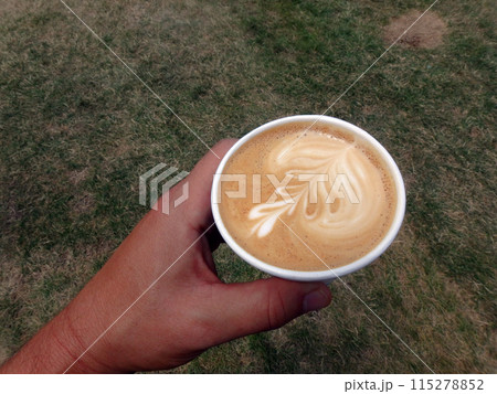 Holding a styrofoam cup of Cappuccino 115278852