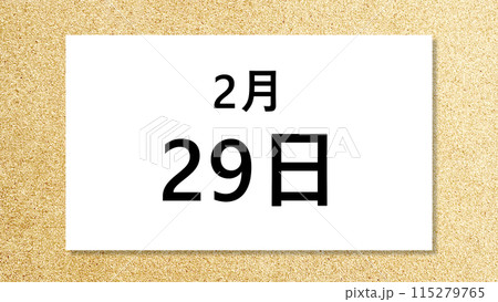 コルク背景の上に置いた2月29日の文字入り白紙_ワイド 115279765
