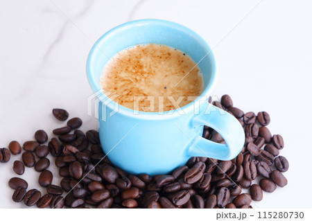 エスプレッソに牛乳をたっぷり入れたコーヒーのカフェ・ラッテと、深煎りしたコーヒー豆 115280730