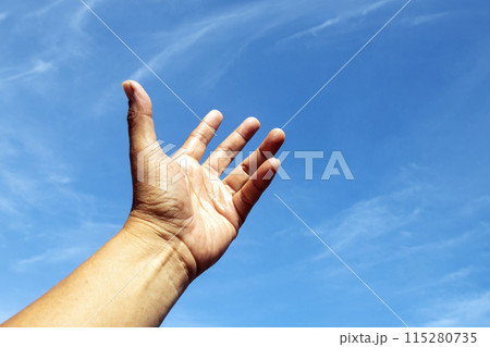 One left hand reaching up to the bright blue sky in hope. One left hand reaching up to the bright blue sky in hope. 115280735