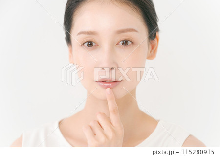 口元を指差す女性の写真 口元を指差す女性の写真 115280915