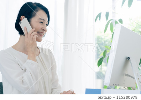 スマホで会話をするビジネスウーマン スマホで会話をするビジネスウーマン 115280979