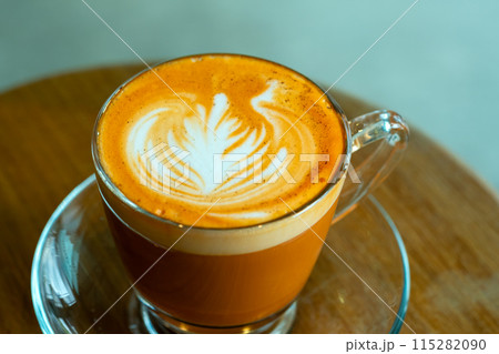 Close up beautifully crafted latte with intricate swan art in frothy milk, served in clear glass cup on wooden table Close up beautifully crafted latte with intricate swan art in frothy milk, served in clear glass cup on wooden table 115282090