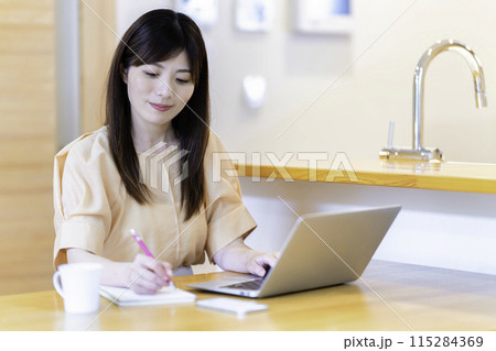 ダイニングテーブルで勉強する女性 ダイニングテーブルで勉強する女性 115284369
