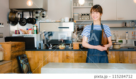 客を迎える女性カフェスタッフ 客を迎える女性カフェスタッフ 115284712