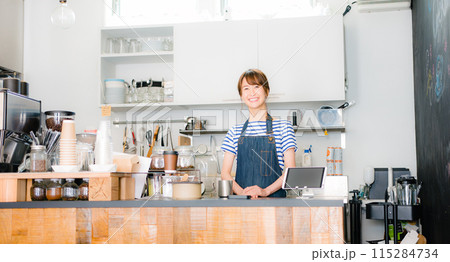 客を迎える女性カフェスタッフ 115284734
