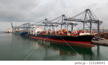 Cargo container ship at terminal sea port during stormy weather and grey clouds, Container ship loading and unloading freight shipping import export logistic cargo container. Cargo container ship at terminal sea port during stormy weather and grey clouds, Container ship loading and unloading freight shipping import export logistic cargo container. 115286041