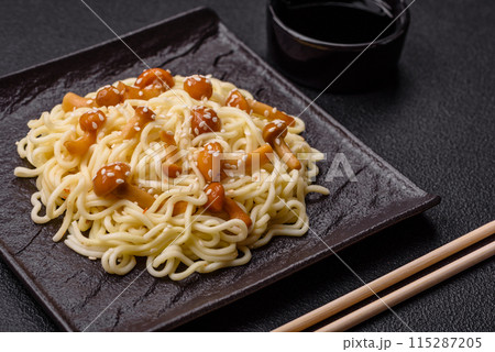 Delicious Asian cuisine dish with rice noodles, peppers, mushrooms and spices Delicious Asian cuisine dish with rice noodles, peppers, mushrooms and spices 115287205