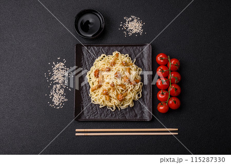 Delicious Asian cuisine dish with rice noodles, peppers, mushrooms and spices Delicious Asian cuisine dish with rice noodles, peppers, mushrooms and spices 115287330