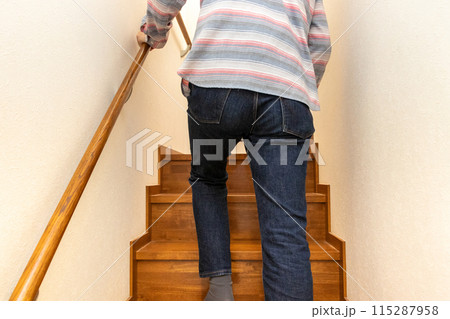 手すりを握って階段を上る男性の後ろ姿 115287958
