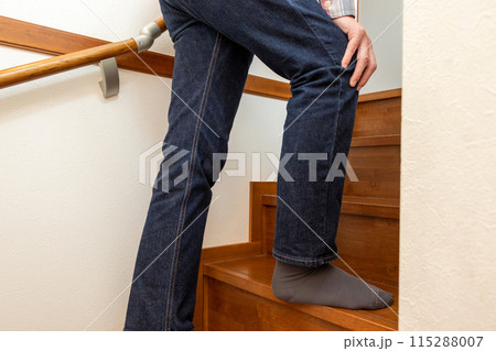 膝に手を当てて階段を上る男性 115288007