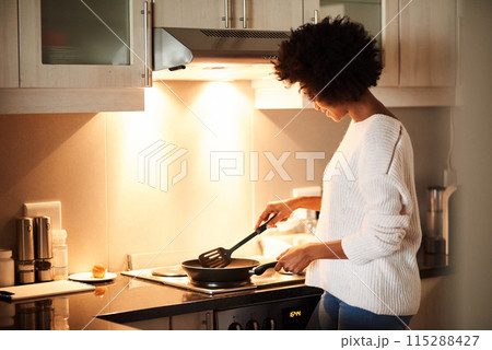 Black woman, pan and cooking on stove in home, frying and meal preparation in kitchen. Female person, apartment and nutrition in food, diet and wellness for cuisine on gas for dinner routine in house 115288427