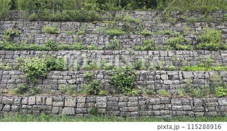 Gabion retaining wall made of gabion baskets with gabion stones. Textured background Gabion retaining wall made of gabion baskets with gabion stones. Textured background 115288916