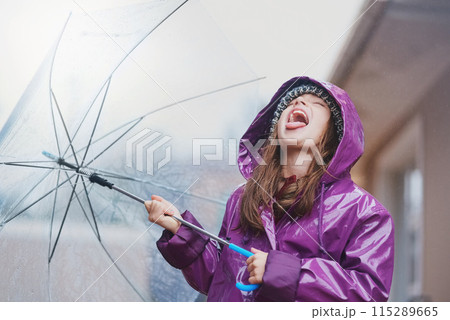 Rain, umbrella and child with tongue out for outdoor fun, happiness and growing up in coat. Winter, girl or kid in city with open mouth to taste or catch water drops for freedom, cold weather or play 115289665