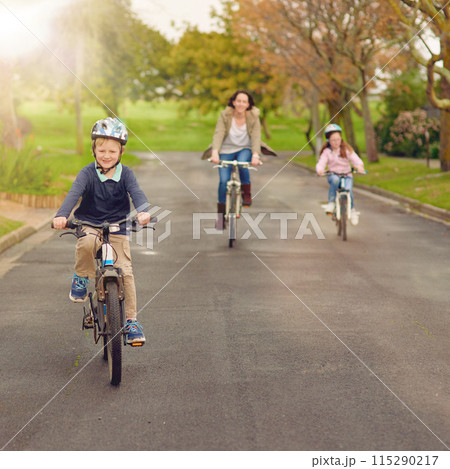 Boy, family and bicycle for fun outside, road and mother with sister in nature for bonding and childhood development. Growth, helmet and safety, riding and children in neighbourhood with parent 115290217