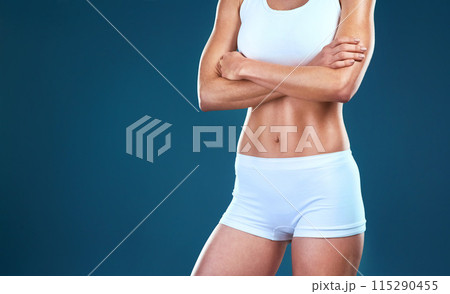 Arms crossed, body and fitness with woman on space in studio isolated on blue background closeup. Exercise, gym and health with confident sports athlete in underwear for training, wellness or workout 115290455