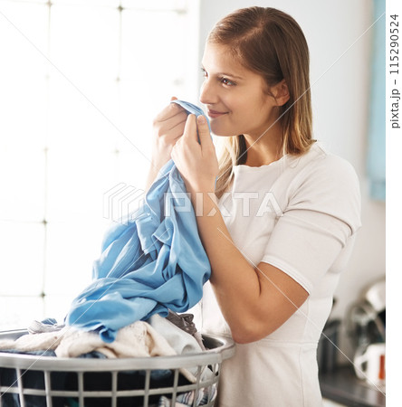 Laundry, clean and woman smelling clothes after freshening, housework and washing material in morning. Chores, housekeeping and cleaner or female person with basket, fabric or soft cotton in home 115290524