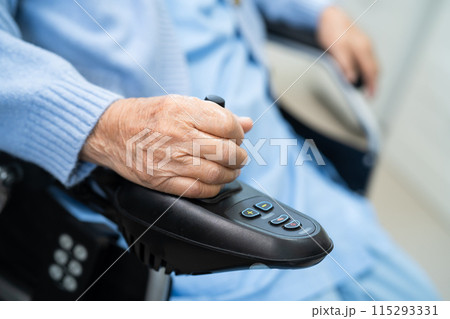 Asian senior woman patient on electric wheelchair with remote control at hospital. 115293331