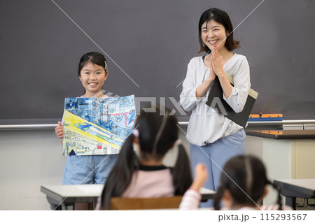 描いた絵や工作を学校で発表する子供と先生　よくできました 115293567